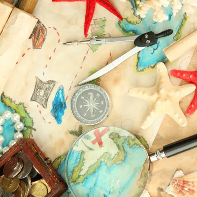Map of the world, with a compass, treasure chest, and stars